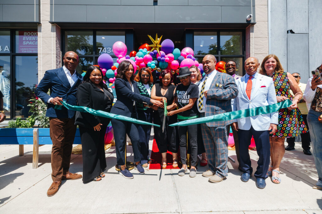 Store owner of The Counter Karylta Williams cuts the green ribbon, surrounded by loved ones and city government members, including Mayor Sheffield.