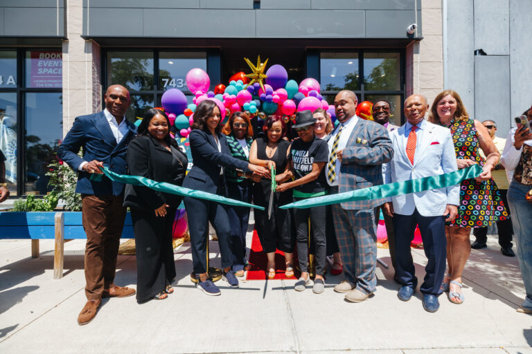 Store owner of The Counter Karylta Williams cuts the green ribbon, surrounded by loved ones and city government members, including Mayor Sheffield.